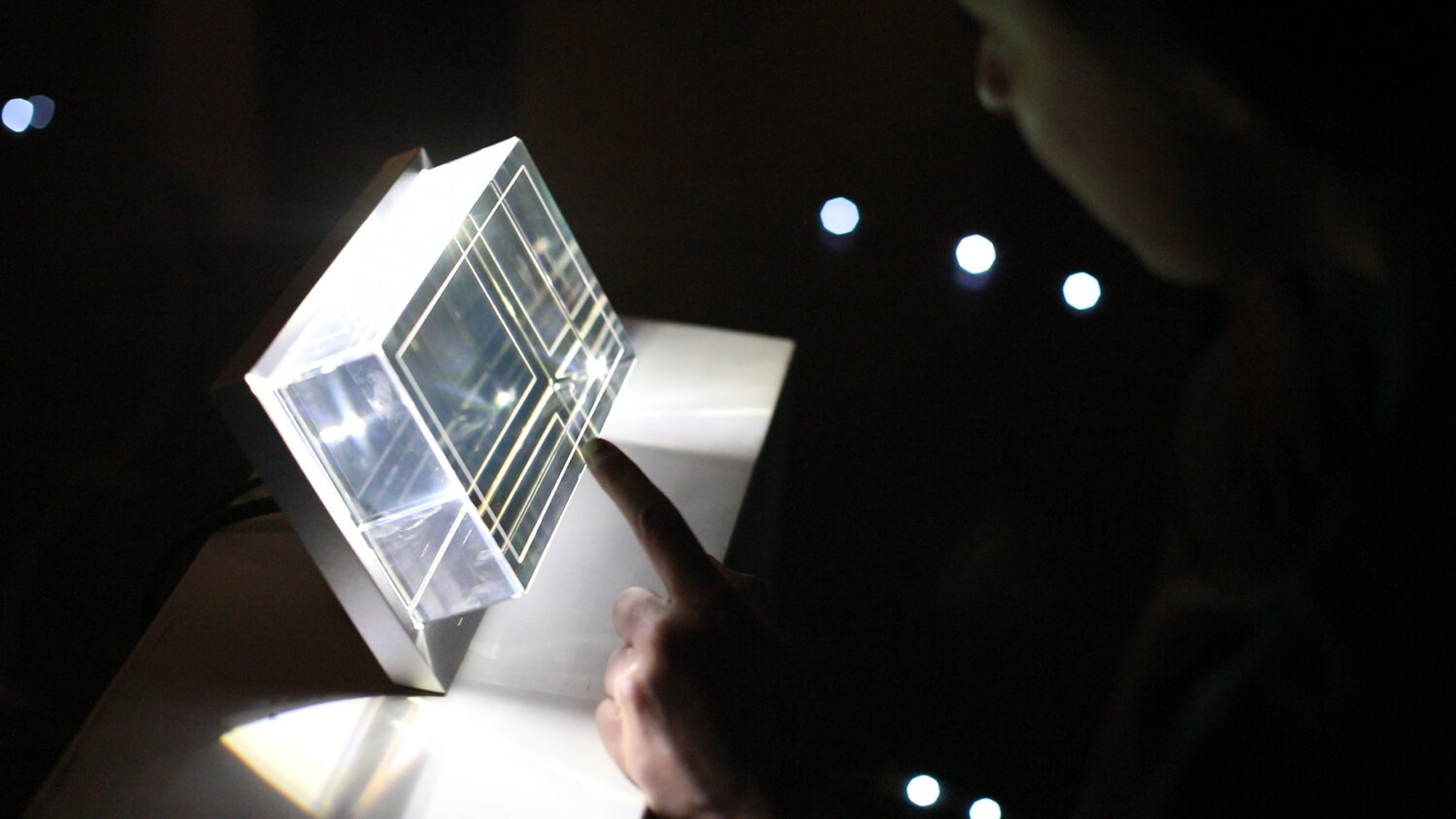 The central āhologram finaleā prototypeāa clear acrylic cube with etched concentric linesāemits light to form a low-fi planet model, visualizing the cumulative impact of each teamās energy choices.